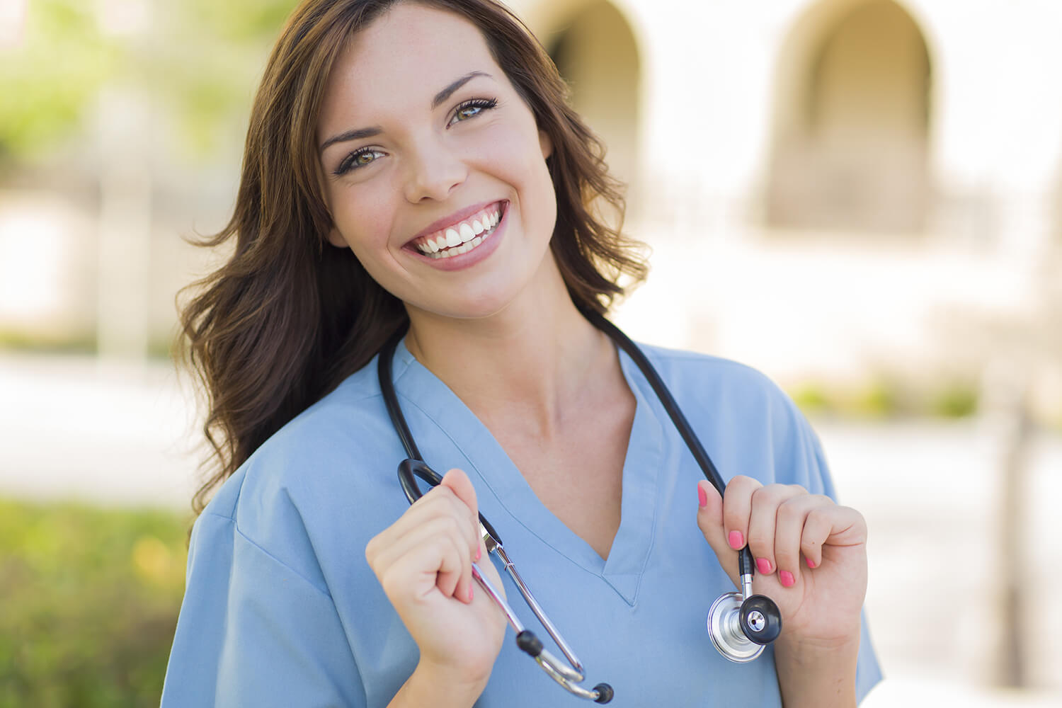 Female nurse in blue scrubs with stethoscope